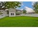 Back exterior view of the home with a large yard and neutral paint at 3614 W Platt St, Tampa, FL 33609