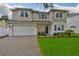 Charming two-story home with a manicured lawn, brick driveway, and a two-car garage at 3614 W Platt St, Tampa, FL 33609