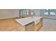 Modern kitchen island with sink, dishwasher, hardwood floors, and access to the backyard at 3614 W Platt St, Tampa, FL 33609