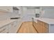 Bright kitchen boasts white cabinets, a farmhouse sink, stainless steel appliances, and an island with seating at 3614 W Platt St, Tampa, FL 33609