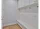 Bright and modern mudroom with white cabinets, bench, drawers, beadboard and hardwood floors at 3614 W Platt St, Tampa, FL 33609