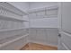 Well-organized walk-in closet with white shelving units and hardwood flooring at 3614 W Platt St, Tampa, FL 33609