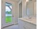 Bathroom with a white vanity, sink, and a glass door leading to the backyard at 3616 W Platt St, Tampa, FL 33609