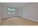 Open bedroom with hardwood floors, a large window, and access to an ensuite at 3616 W Platt St, Tampa, FL 33609
