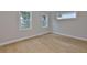 Bright bedroom with a hardwood floor and large windows with trim overlooking the front yard at 3616 W Platt St, Tampa, FL 33609