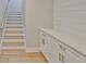 Hallway with stairs and white cabinets with gold hardware and a butcher block countertop at 3616 W Platt St, Tampa, FL 33609