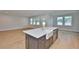 Open-concept kitchen with an island with a farmhouse sink, stainless steel appliances, and hardwood floors at 3616 W Platt St, Tampa, FL 33609