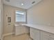 Bright laundry room with sink, countertop, and ample cabinet space at 3616 W Platt St, Tampa, FL 33609