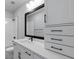 Stylish bathroom featuring white cabinetry, a black framed mirror, and elegant fixtures at 406 N Westland St # 1, Tampa, FL 33609