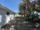 Side yard featuring lush landscaping and a white fence at 4322 Baden Dr, Holiday, FL 34691