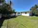 Landscaped backyard with healthy green grass and a white picket fence at 4322 Baden Dr, Holiday, FL 34691
