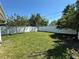Backyard featuring a well maintained lawn and secure white fence at 4322 Baden Dr, Holiday, FL 34691