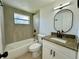 Bathroom featuring granite counters, modern fixtures, and a tiled shower-tub at 4322 Baden Dr, Holiday, FL 34691