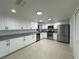 Modern kitchen featuring stainless steel appliances, white cabinets, and granite countertops at 4322 Baden Dr, Holiday, FL 34691