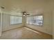 Bright living room featuring tile flooring, large windows, and a modern ceiling fan at 4322 Baden Dr, Holiday, FL 34691