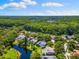 Aerial view showcasing the neighborhood with ponds and mature landscaping throughout at 4690 Wrentham Pl, Palm Harbor, FL 34685