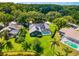 Stunning aerial view of home featuring a screened-in pool, solar panels, and lush landscaping at 4690 Wrentham Pl, Palm Harbor, FL 34685