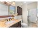 Bathroom featuring granite countertop vanity, framed mirror, and glass-enclosed shower at 4690 Wrentham Pl, Palm Harbor, FL 34685