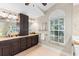 Bathroom with double vanity, granite counters, and abundant natural light at 4690 Wrentham Pl, Palm Harbor, FL 34685