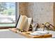 Close-up on a bathtub with a wine glass and book resting on a wooden tray at 4690 Wrentham Pl, Palm Harbor, FL 34685