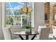 Bright dining area featuring a chandelier, view of backyard, and seating for four at 4690 Wrentham Pl, Palm Harbor, FL 34685
