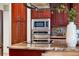 Cherry wood cabinets surround stainless steel appliances with black countertops in the spacious kitchen at 4690 Wrentham Pl, Palm Harbor, FL 34685