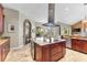 Modern kitchen with granite countertops, an island cooktop, and stainless steel appliances at 4690 Wrentham Pl, Palm Harbor, FL 34685