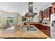 Open concept kitchen featuring stainless steel appliances, cooktop island, and custom cabinetry at 4690 Wrentham Pl, Palm Harbor, FL 34685