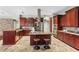 Gourmet kitchen featuring custom cabinetry, granite countertops, and a stainless steel island hood at 4690 Wrentham Pl, Palm Harbor, FL 34685