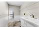 Laundry room featuring a utility sink, upper shelving, and linoleum flooring at 4690 Wrentham Pl, Palm Harbor, FL 34685