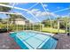 Refreshing screened-in pool with clear blue water and brick paver surround offers a private retreat at 4690 Wrentham Pl, Palm Harbor, FL 34685