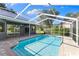 Exterior view showcases a screened-in pool area and spacious patio at 4690 Wrentham Pl, Palm Harbor, FL 34685