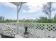 Cozy balcony featuring lattice railings, comfortable seating, and pleasant treetop views at 623 Garland Cir, Indian Rocks Beach, FL 33785
