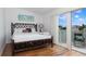 Bright bedroom featuring a decorative bamboo bed frame and a sliding glass door with balcony at 623 Garland Cir, Indian Rocks Beach, FL 33785