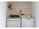 Efficient laundry room includes a white washer, dryer and overhead shelving at 623 Garland Cir, Indian Rocks Beach, FL 33785