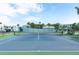 Well-maintained community tennis court surrounded by lush greenery, seating, and blue skies at 623 Garland Cir, Indian Rocks Beach, FL 33785