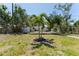 Backyard featuring tree in the center and additional storage unit and grassy space at 6750 Hibiscus S Ave, South Pasadena, FL 33707