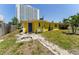 Exterior backyard featuring path leading to the home and bright yellow paint and blue door at 6750 Hibiscus S Ave, South Pasadena, FL 33707