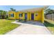 View of the yellow house featuring a covered parking area with blue doors and white trim at 6750 Hibiscus S Ave, South Pasadena, FL 33707