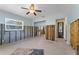 Living room featuring doorway to another room, tile floors, ceiling fan, and wood walls at 6750 Hibiscus S Ave, South Pasadena, FL 33707