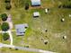 Aerial view of property featuring a house, outbuildings, and pasture, showcasing its spaciousness at 7627 Artifact Dr, Zephyrhills, FL 33541
