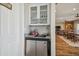 Charming bar area featuring glass-front cabinets, granite countertop, and a beverage refrigerator at 7627 Artifact Dr, Zephyrhills, FL 33541