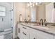 This bathroom features a double vanity with white cabinets, granite counters, and tiled walk-in shower at 7627 Artifact Dr, Zephyrhills, FL 33541