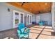 Inviting covered patio featuring blue Adirondack chairs and a wood plank ceiling at 7627 Artifact Dr, Zephyrhills, FL 33541