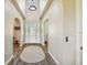 Bright and airy foyer with high ceilings, decorative lighting, and views of adjoining living areas at 7627 Artifact Dr, Zephyrhills, FL 33541
