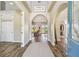 Inviting foyer with wood-look tile, arched doorways, and a view into the living room at 7627 Artifact Dr, Zephyrhills, FL 33541