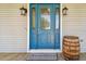 Close-up of a bright blue front door, decorative glass, stylish lanterns, and a welcome mat at 7627 Artifact Dr, Zephyrhills, FL 33541