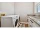 Functional laundry room with washer, dryer, granite countertop and cabinet at 7627 Artifact Dr, Zephyrhills, FL 33541