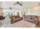 Spacious living room featuring plush furniture, ceiling fans, and an open floor plan at 7627 Artifact Dr, Zephyrhills, FL 33541