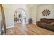 Open-concept living space with archways, wood floors, and a comfortable seating area at 7627 Artifact Dr, Zephyrhills, FL 33541